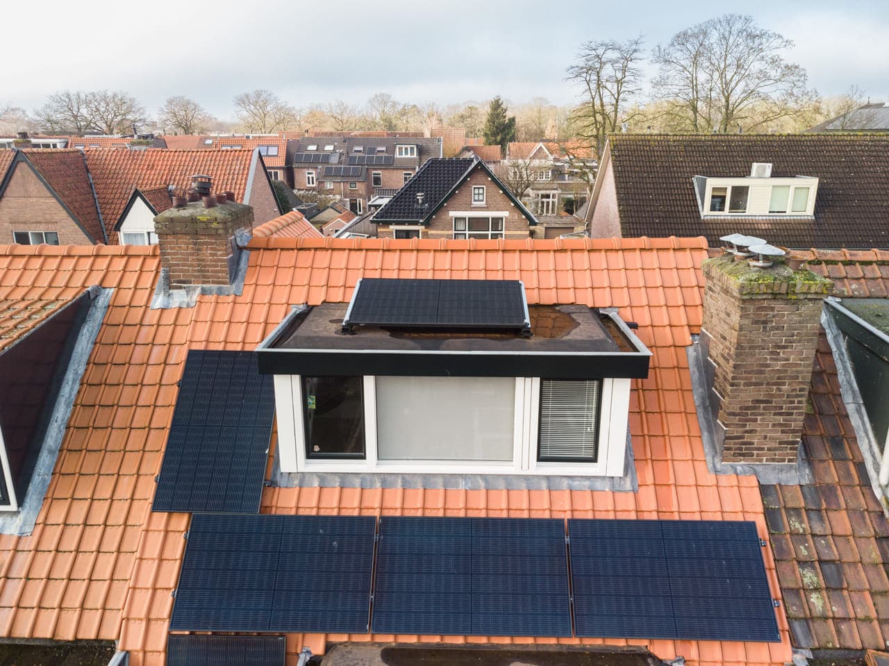 Panelen op dak, hoogte, wijk op achtergrond.