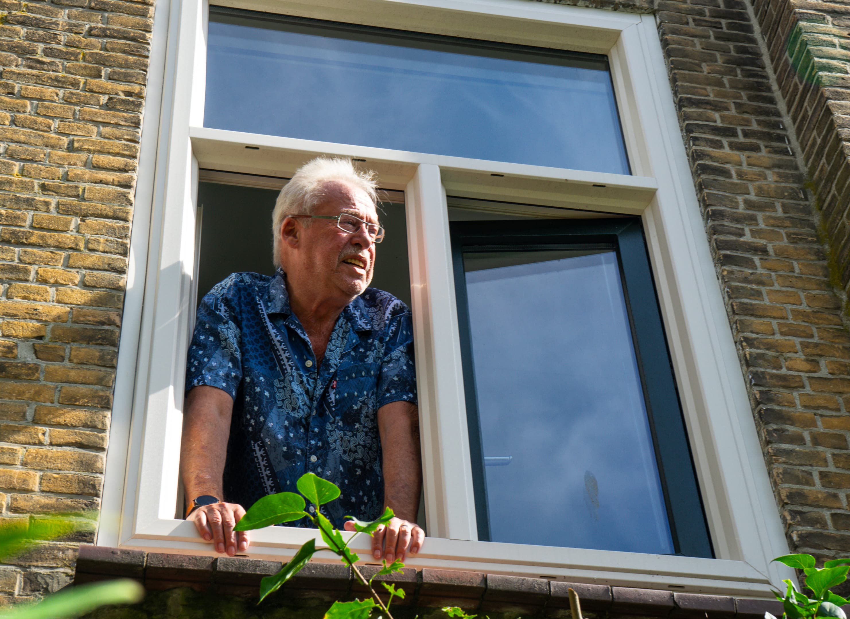 Meneer Valk leunt uit zijn raam