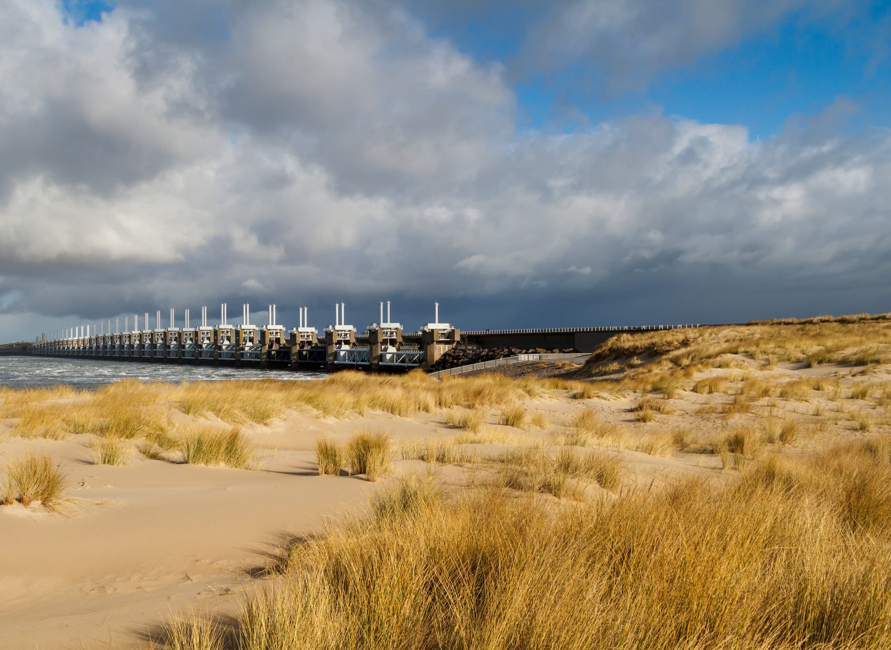 Deltawerken bij de Oosterschelde vanuit de verte genomen, duinlandschap op de voorgrond