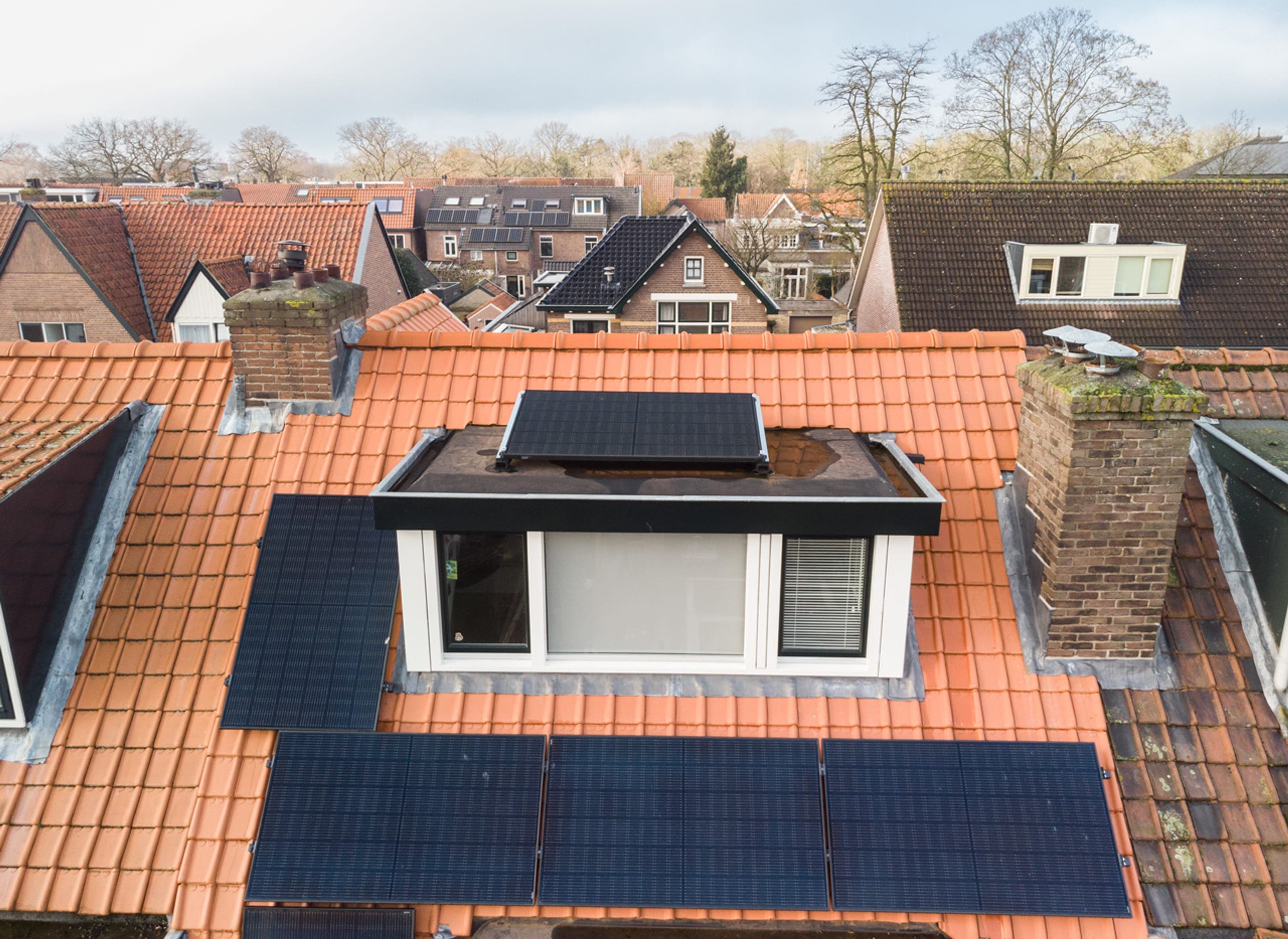 Panelen op dak van de dakkapel, hoogte, wijk op achtergrond.