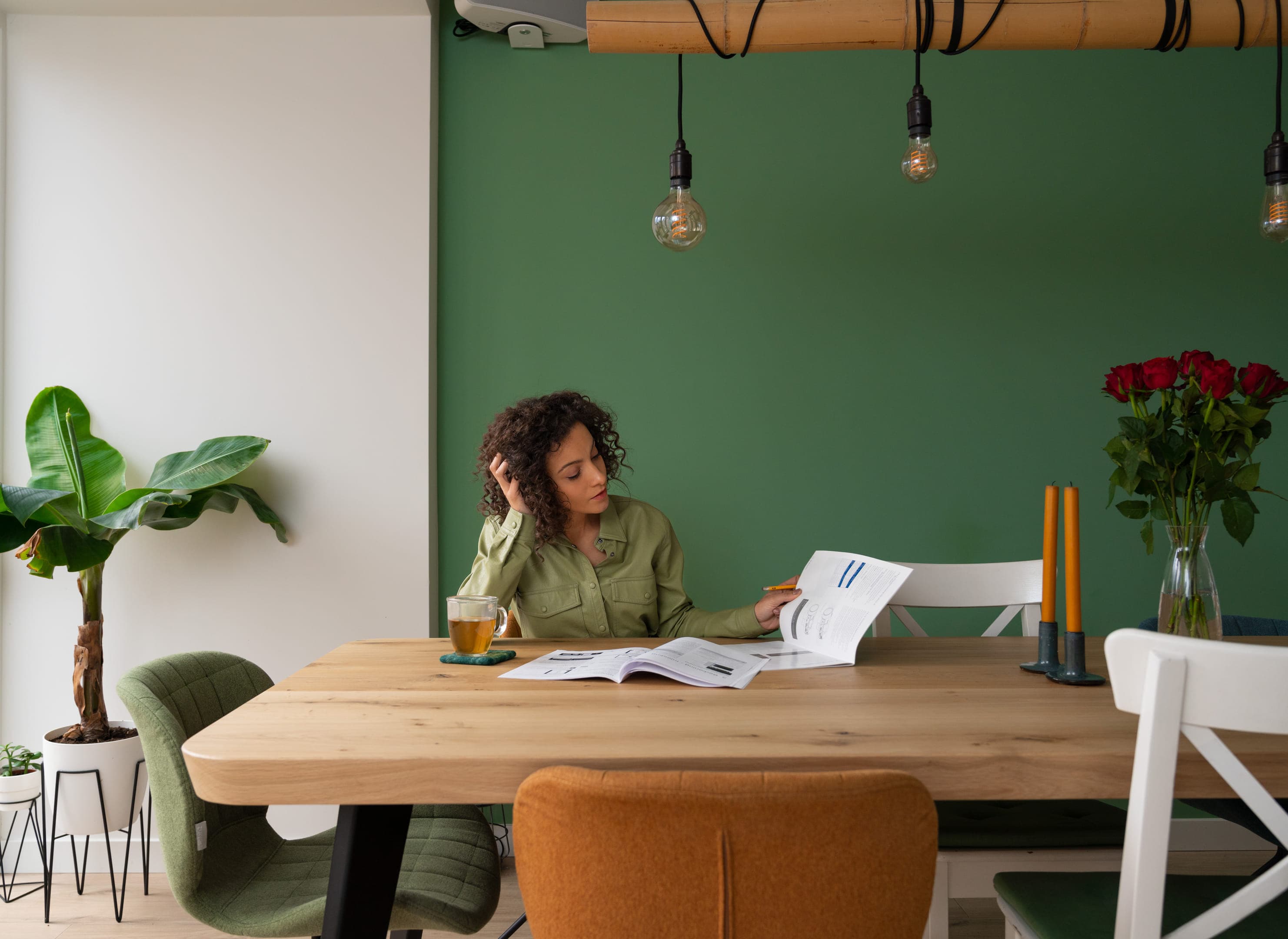 Vrouw achter keukentafel met informatie over energiebesparende maatregelen, zonder computer.